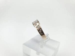 Gold ring with geometric diamond accents.