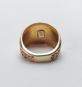 Gold ring with intricate floral design.