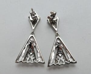 Silver triangular earrings with geometric design.
