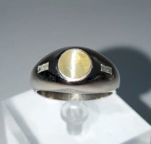 Silver ring with yellow gemstone centerpiece.