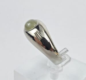 Silver ring with gemstone and rectangular accent.