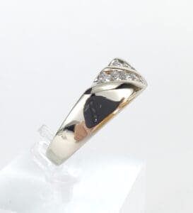 Silver ring with diamonds on display stand.