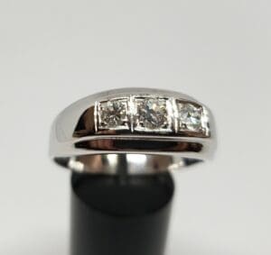 Silver ring with three square diamonds.