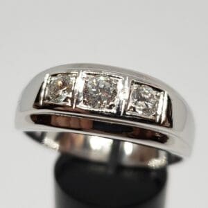 Silver ring with three square diamonds.
