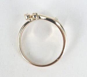 Gold ring with square diamonds on top.