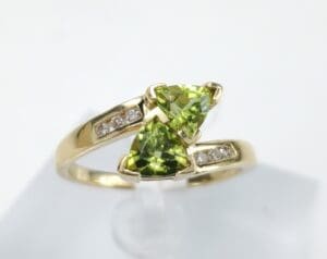Gold ring with green gemstones and diamonds.