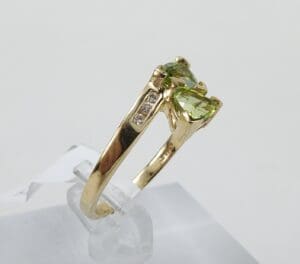 Gold ring with green gemstone and diamonds.