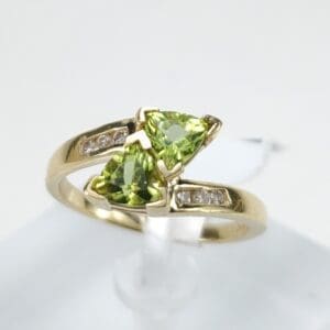 Gold ring with green gemstones and diamonds.
