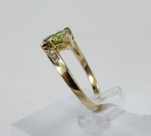 Gold ring with green gemstone on display.