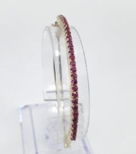 Gold hoop earrings with pink gemstones.