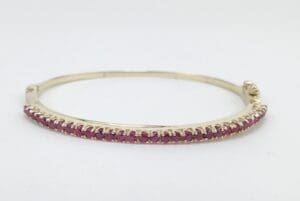 Gold bracelet with pink gemstones.
