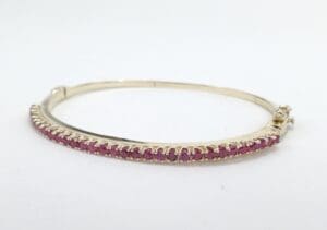 Gold bracelet with pink gemstones.