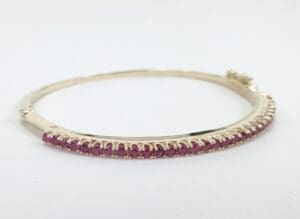 Gold bracelet with pink gemstones.