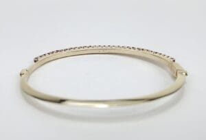 Gold bangle bracelet with small gemstones.