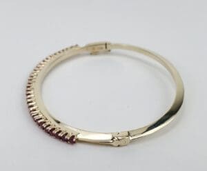 Gold bracelet with purple gemstone accents.