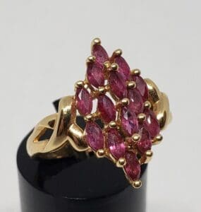 Gold ring with cluster of pink gemstones.
