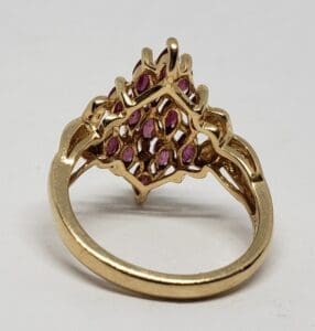 Gold ring with purple gemstones, intricate design.