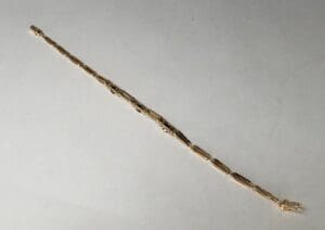 Gold chain bracelet on white background.