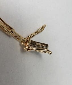 Gold clasp with engraved text on it.