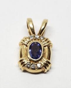 Gold pendant with blue and white stones.