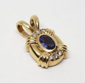 Gold pendant with blue stone and diamonds.