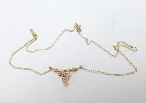 Gold necklace with intricate pendant design.