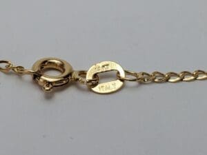 Gold chain clasp with hallmark markings.