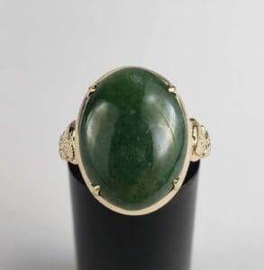 Gold ring with large green stone.