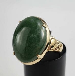 Gold ring with large green gemstone.