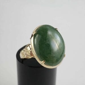 Gold ring with large green gemstone.