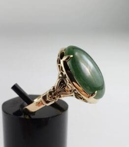 Gold ring with large green stone.