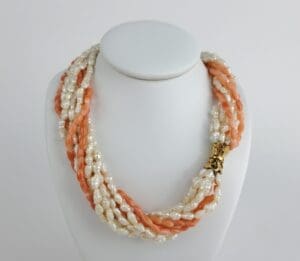 Twisted pearl and coral necklace display.