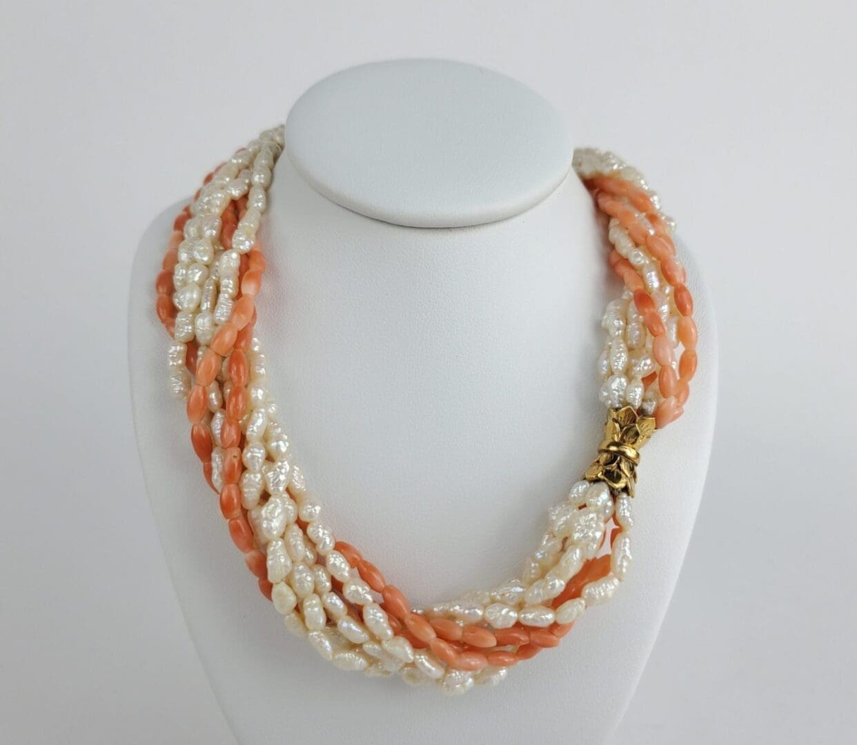 Twisted pearl and coral necklace display.