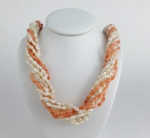 Twisted pearl and coral necklace on display.