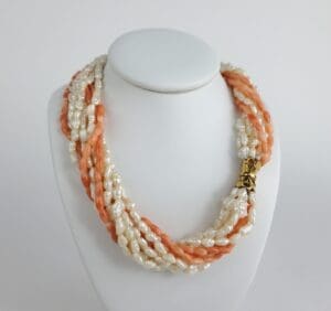 Pearl and coral necklace on display stand.