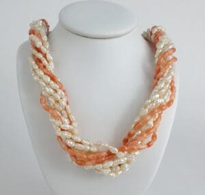 Pearl and coral twisted necklace on display.