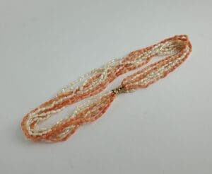 Orange and white beaded necklace on display.