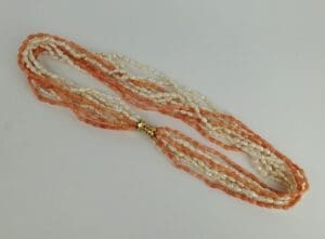 Orange and white beaded necklace with clasp.
