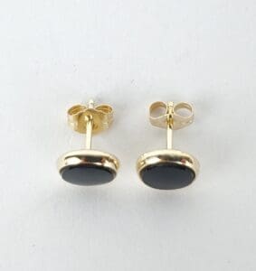 Gold earrings with black stone studs.