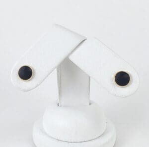 Gold cufflinks with black stones displayed.