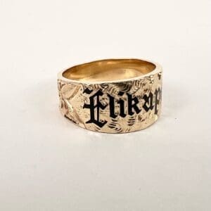 Gold ring with engraved black lettering.