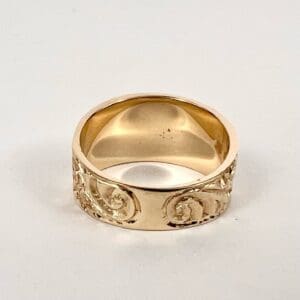 Gold ring with intricate engraved design.
