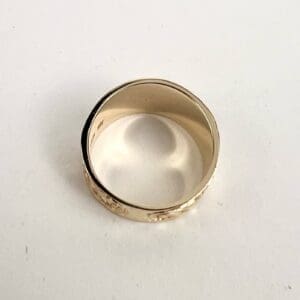 Gold ring with engraved floral design.