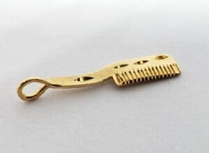 Golden comb with decorative handle design.