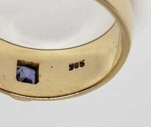 Gold ring with gemstone and "585" hallmark.