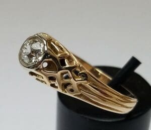 Gold ring with intricate design and diamond.