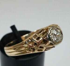 Gold ring with intricate design and diamond.