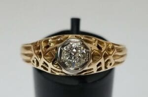 Gold ring with intricate, cut-out design.
