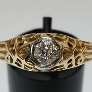 Gold ring with intricate, cut-out design.