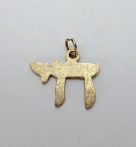 Gold Hebrew letter pendant on white background.